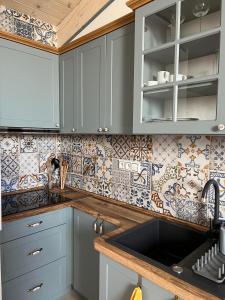 波普拉德Vila Liberta的厨房配有蓝色橱柜,墙上铺有瓷砖。