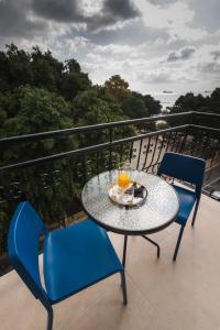 利马索尔Chrielka Hotel的阳台配有桌椅和桌子及饮料