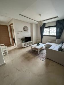 拉巴特Lovely Appartement Prestigia Hayriad的客厅配有沙发和桌子