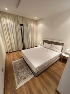 拉巴特Lovely Appartement Prestigia Hayriad的卧室配有一张白色的大床,铺有木地板