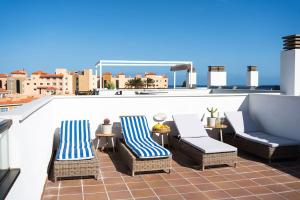 卡勒达德福斯特Sunny Luxury Apartment with two-level terrace, two swimming pools, next to golf course的屋顶上带桌椅的天井