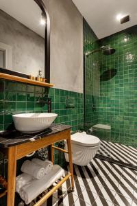 伊斯坦布尔World House Boutique Hotel Galata的绿色瓷砖浴室设有水槽和卫生间