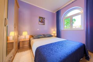 波拉特Apartments Mira的紫色卧室设有一张床和一个窗户