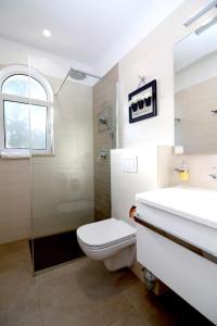 波拉特Apartments Mira的浴室配有卫生间、淋浴和盥洗盆。