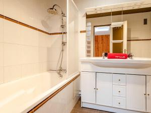 多维尔Apartment Les Cigognes by Interhome的浴室配有盥洗盆、浴缸和镜子