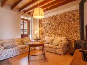 森瑟勒斯Holiday Home Can Xerret by Interhome的客厅设有两张沙发和一堵石墙