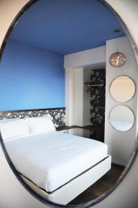 马切拉塔Le Dimore del Centrale的一间设有一张镜子内的白色床的卧室