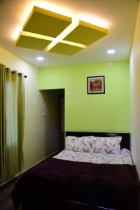 瓦加蒙SPATHODEA的一间卧室设有一张黄色天花板的床