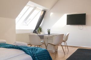 维也纳Vibrant Aparment perfect for Long Stays的一间卧室配有桌椅和电视