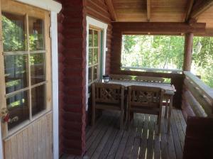 ToivakkaPäivänsäde Cottage的小屋的门廊配有桌椅