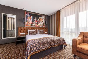 斯文托伊Resort Hotel Elija的配有一张床和一把椅子的酒店客房