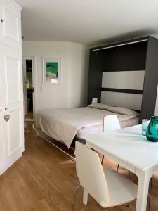 圣莫里茨Ferienapartment in Bestlage in Sankt Moritz的一间卧室配有一张床和一张桌子及椅子