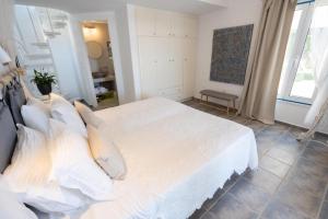 KrotiriKaiya Villas的卧室配有一张带白色床单和枕头的大床。