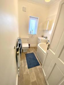 伯肯黑德Merseyside的一间带白色浴缸、卫生间和窗户的浴室