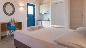 基莫洛斯岛Themonia Studios Kimolos的卧室配有一张白色大床和一扇蓝色门
