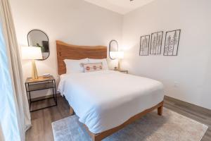 帕尔默Colony Suites的卧室配有一张白色大床和两面镜子