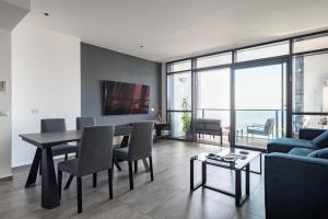 巴特亚姆Luxury Two Bedroom Seaview Apt的客厅配有桌子和蓝色沙发