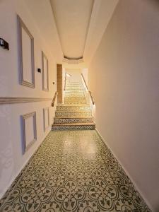 卡塔赫纳Hotel Casa Agustina的一条带图案地板的楼梯的长走廊