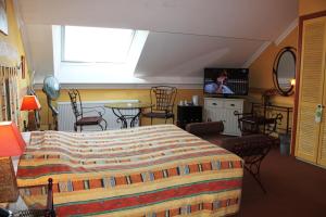 弗朗科尔尚Hotel Le Relais de Pommard的一间卧室配有一张床和一台平面电视