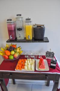 累西腓Suites Residence的一张桌子,上面放着一大堆水果,蔬菜和饮料