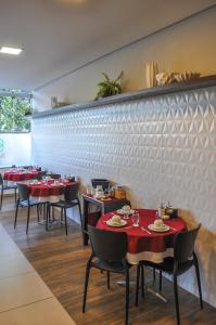 累西腓Suites Residence的餐厅的一排红桌