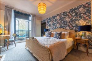 布罗姆利皇冠旅馆的一间卧室配有一张带花卉壁纸的大床