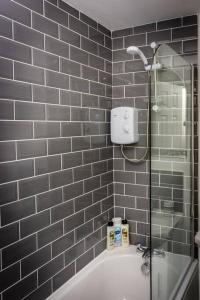 格拉斯哥Modern bright studio apartment in south Glasgow的带淋浴和浴缸的浴室