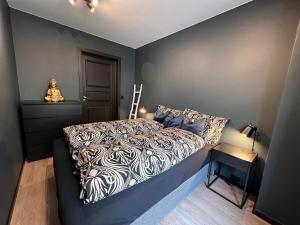 诺托登Notodden Sentrum Apartment NO 11的一间卧室配有一张带黑白色棉被的床