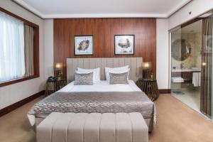 伊斯坦布尔Vogue Hotel Supreme Istanbul的一间卧室配有一张大床和镜子