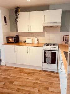 布莱顿霍夫Penthouse Sea view home的厨房配有白色橱柜和炉灶烤箱。