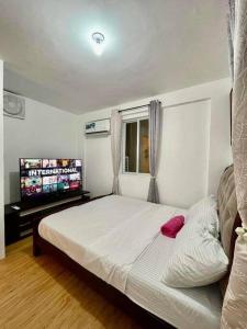 武端市Lily’s Homestay的一间卧室配有一张床和一台平面电视