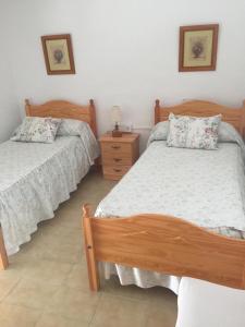 莱斯卡瑟斯-达尔卡纳Casa Gloria 2的一间卧室设有两张单人床和一个床头柜。