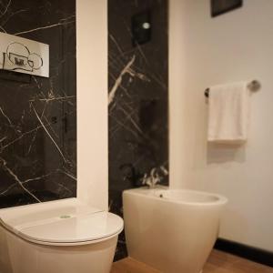维泰博ArtGallery Apartment - Villa immersa nel verde - Deluxe的浴室配有白色卫生间和淋浴。