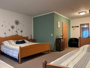 奎德林堡Landhaus Pusteblume的一间卧室设有两张床,拥有绿色的墙壁
