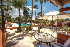 阿尔曼萨Quinta dos Amigos的一个带桌子和遮阳伞的庭院和一个游泳池