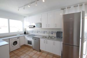 迈阿密普拉特亚Villa Atenea的厨房配有白色橱柜和不锈钢冰箱