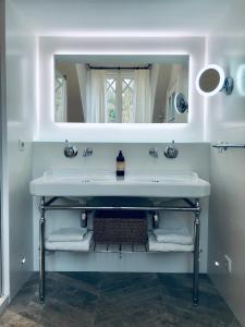 吉维尼Orpheus Lodge的一间带水槽和镜子的浴室