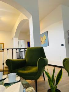 维泰博ArtGallery Apartment - Villa immersa nel verde - Deluxe的客厅配有绿色椅子和桌子