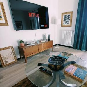 维泰博ArtGallery Apartment - Villa immersa nel verde - Deluxe的客厅配有玻璃桌和电视