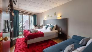 艾克斯莱班柏爱特酒店的一间卧室配有一张红色地毯和一张沙发。