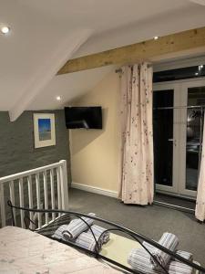 法尔茅斯Garden Room @ Bosanath Mill的一间卧室配有一张床和一台电视。