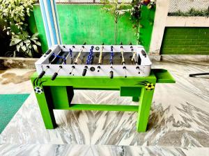 巴拉特布尔Paris Guest House的一张坐在绿色长凳上的乒乓球桌