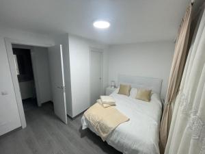 托雷洪-德阿尔多斯Tu precioso piso en el centro de Torrejón的白色的卧室设有床和窗户