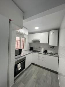 托雷洪-德阿尔多斯Tu precioso piso en el centro de Torrejón的白色的厨房设有水槽和炉灶。