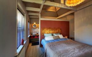 托伦Villa Azura的一间卧室设有一张红色墙壁的大床