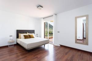 洛斯克里斯蒂亚诺斯Villa esclusiva a 1 chilometro da Playa de Los Cristianos的白色卧室配有床和镜子