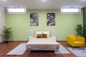 洛斯克里斯蒂亚诺斯Villa esclusiva a 1 chilometro da Playa de Los Cristianos的一间卧室配有一张床和一张黄色椅子