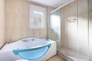 洛斯克里斯蒂亚诺斯Villa esclusiva a 1 chilometro da Playa de Los Cristianos的带浴缸和玻璃淋浴间的浴室。