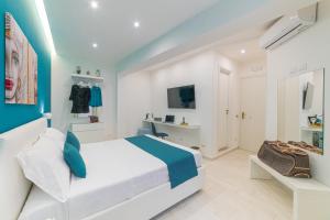 贾迪尼-纳克索斯I Mori dell’Etna的白色和蓝色的卧室设有床和电视