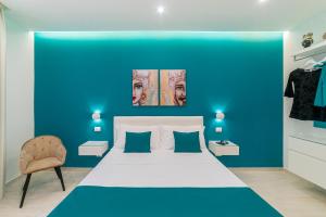 贾迪尼-纳克索斯I Mori dell’Etna的蓝色的卧室设有白色的床和蓝色的墙壁